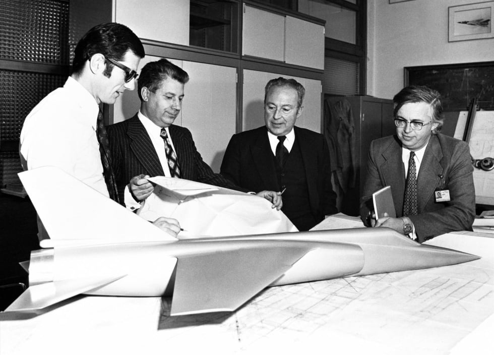 De gauche à droite : Bruno Revellin-Falcoz, Jacques Samin, Jean Cabrière, Pierre Bohn autour d'une table à dessin avec une maquette du Mirage F1 au Bureau d'études de Saint-Cloud